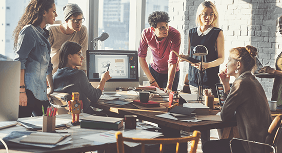 group of employees gathered around a desk