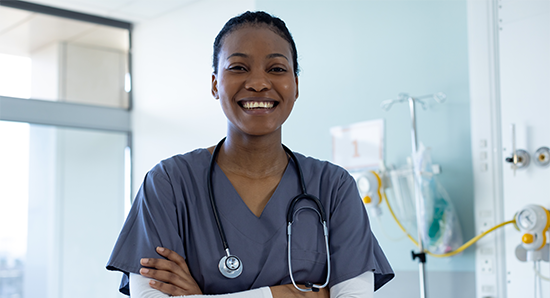 Portrait of happy female nurse in hospital room